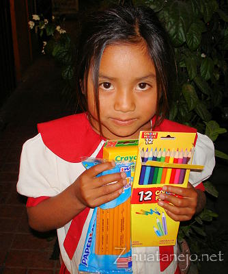 Niña con útiles escolares donados Niña con útiles escolares donados